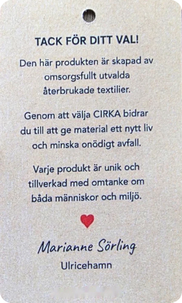 Baksidan av Cirkas hangtag: Tack för ditt val! Den här produkten är skapad av omsorgsfullt utvalda återbrukade textiler. Signerad Marianne Sörling, Ulricehamn